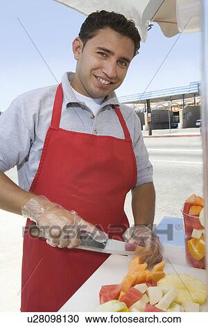 Portrait of male street vendor chopping fruit View Large Photo Image Stock Image - Portrait of male street vendor chopping fruit. Fotosearch