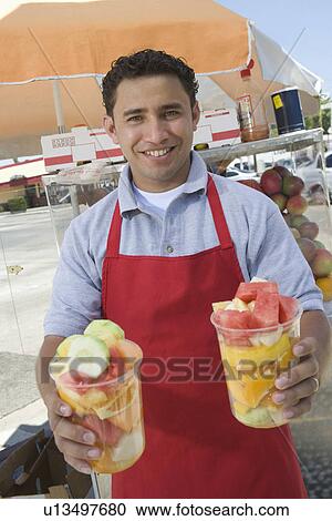 Portrait of male street vendor holding fruit salad View Large Photo Image Stock Image - Portrait of male street vendor holding fruit salad. Fotosearch