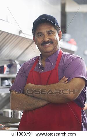Stock Image - Portrait of man in restaurant kitchen. Fotosearch