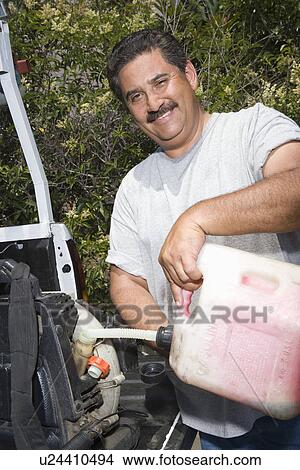 Portrait of man pouring fuel into lawn mower View Large Photo Image Picture - Portrait of man pouring fuel into lawn mower. Fotosearch