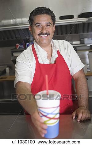 Portrait of man serving drink in restaurant View Large Photo Image Stock Image - Portrait of man serving drink in restaurant. Fotosearch