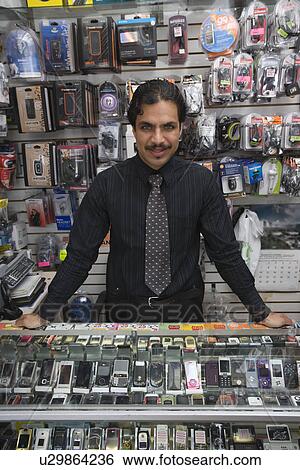 Portrait of man working in mobile phone shop View Large Photo Image Stock Photograph - Portrait of man working in mobile phone shop. Fotosearch