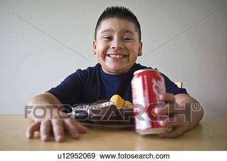 Stock Photo - Portrait of pre-teen (10-12) boy about to eat dessert. Fotosearch
