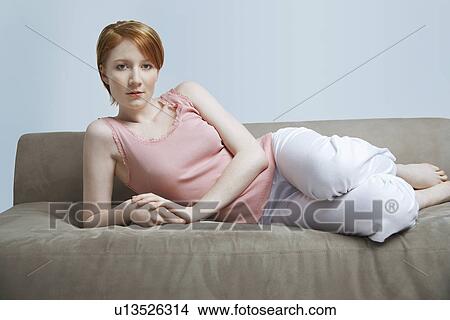 Picture - Portrait of woman lying on sofa. Fotosearch