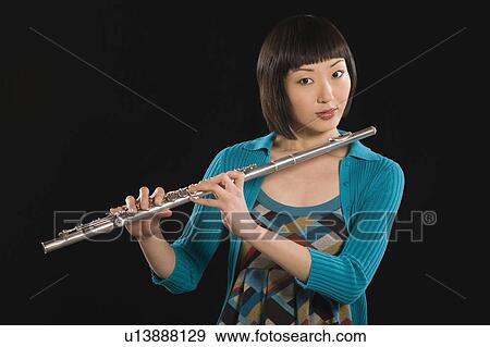 Stock Photo - Portrait of young Korean woman holding flute. Fotosearch