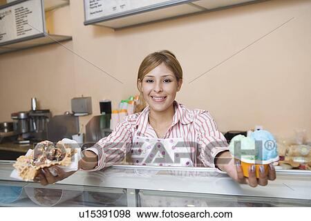 Stock Photo - Portrait of young woman serving ice creams. Fotosearch
