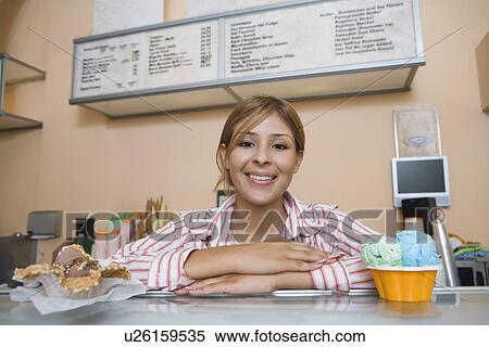 Stock Photography - Portrait of young woman serving ice cream. Fotosearch