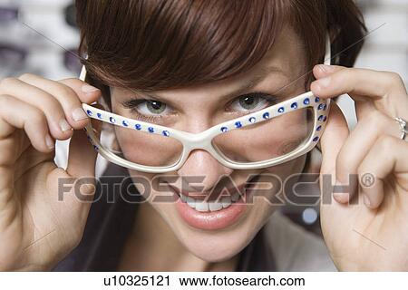 Portrait of young woman wearing glasses View Large Photo Image Stock Image - Portrait of young woman wearing glasses. Fotosearch