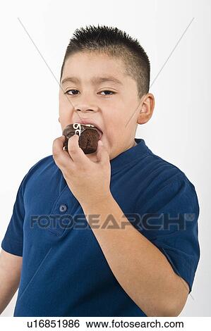 Stock Photograph - Pre-teen (10-12) boy eating cookie. Fotosearch