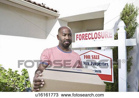 Stock Image - Sad mid adult man moving out of house. Fotosearch