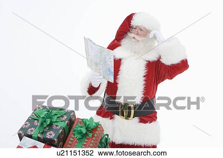 Stock Image - Santa Claus reading map. Fotosearch