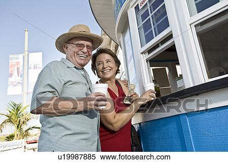 Senior couple buying drinks at food stand View Large Photo Image Stock Photography - Senior couple buying drinks at food stand. Fotosearch
