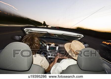 Senior couple driving in convertible on country road at dusk, back view View Large Photo Image Stock Photograph - Senior couple driving in convertible on country road at dusk, back view. Fotosearch