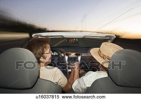 Senior couple driving in convertible on country road at dusk, back view View Large Photo Image Stock Photography - Senior couple driving in convertible on country road at dusk, back view. Fotosearch