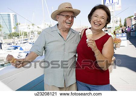 Stock Image - Senior couple holding ice creams. Fotosearch