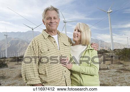 Stock Image - Senior couple near wind farm. Fotosearch