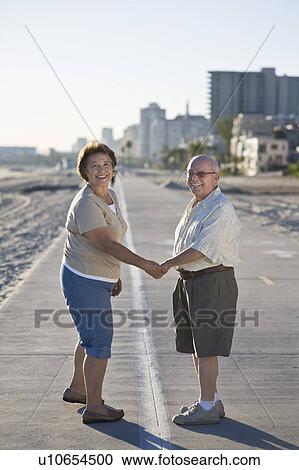 Senior couple on promenade, holding hands View Large Photo Image Stock Image - Senior couple on promenade, holding hands. Fotosearch