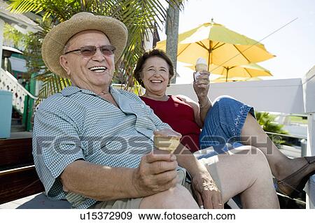 Senior couple sitting on bench and holding ice creams View Large Photo Image Stock Photo - Senior couple sitting on bench and holding ice creams. Fotosearch