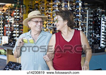 Senior couple trying on funny sunglasses, smiling View Large Photo Image Stock Photo - Senior couple trying on funny sunglasses, smiling. Fotosearch