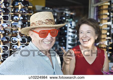 Picture - Senior couple trying on sunglasses, smiling. Fotosearch