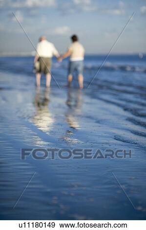 Senior couple walking on beach View Large Photo Image Stock Photo - Senior couple walking on beach. Fotosearch