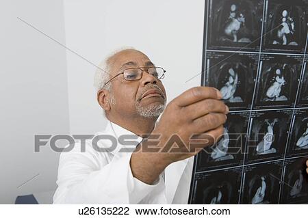Senior healthcare professional examines xray View Large Photo Image Stock Image - Senior healthcare professional examines xray. Fotosearch
