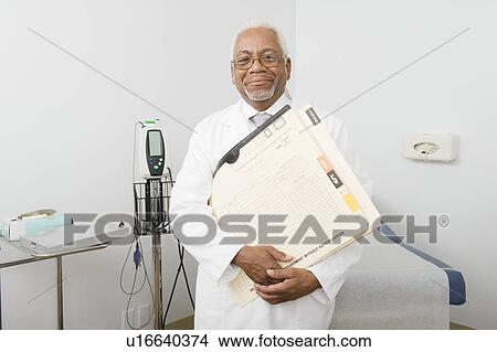 Senior healthcare professional stands with medical records View Large Photo Image Picture - Senior healthcare professional stands with medical records. Fotosearch
