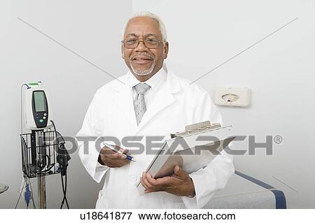 Senior healthcare professional stands with medical records View Large Photo Image Stock Photo - Senior healthcare professional stands with medical records. Fotosearch