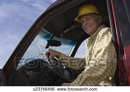 Stock Photograph - Senior man in truck at wind farm. Fotosearch
