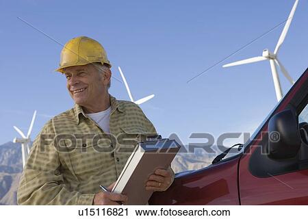 Stock Image - Senior man working at wind farm. Fotosearch
