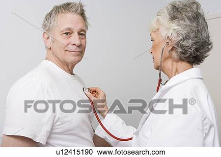 Stock Image - Senior medical practitioner examines man with stethoscope. Fotosearch