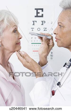 Stock Image - Senior medical practitioner examines eyesight. Fotosearch