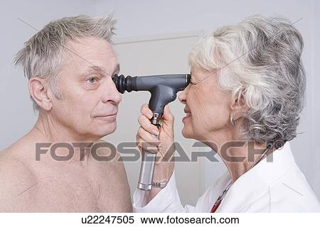 Senior medical practitioner examines man for sight test View Large Photo Image Stock Photography - Senior medical practitioner examines man for sight test. Fotosearch