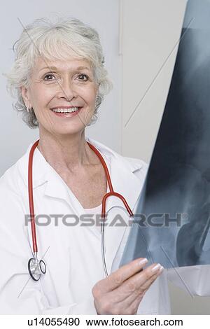 Stock Image - Senior medical practitioner holding xray. Fotosearch