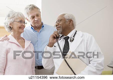 Senior medical practitioner on the phone with a senior couple View Large Photo Image Stock Photograph - Senior medical practitioner on the phone with a senior couple. Fotosearch