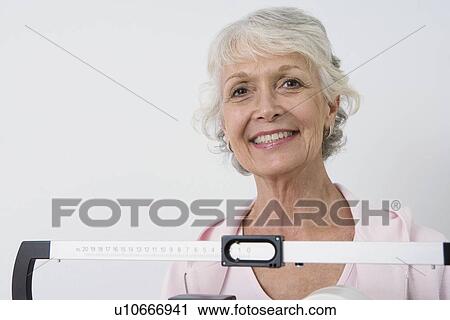 Senior woman stands on hospital scales View Large Photo Image Stock Image - Senior woman stands on hospital scales. Fotosearch