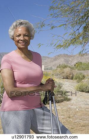 Senior woman stands with walking poles View Large Photo Image Stock Image - Senior woman stands with walking poles. Fotosearch