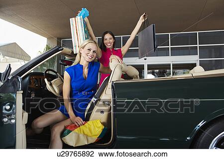 Stock Image - Shoppers in a Convertible. Fotosearch