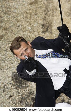 Spy Rappelling and Aiming Gun View Large Photo Image Picture - Spy Rappelling and Aiming Gun. Fotosearch