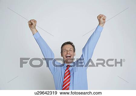 Studio portrait of businessman smiling with arms raised View Large Photo Image Stock Photo - Studio portrait of businessman smiling with arms raised. Fotosearch