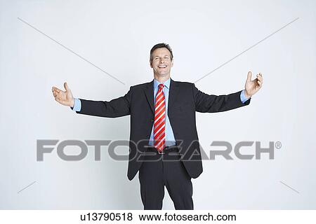 Stock Photo - Studio portrait of businessman with arms outstretched. Fotosearch