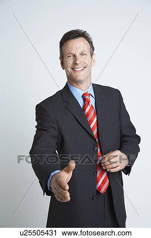 Stock Image - Studio shot of businessman ready to shake hands. Fotosearch