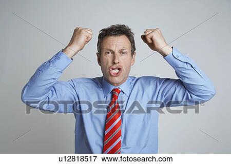 Stock Photo - Studio shot of businessman shaking his fists. Fotosearch