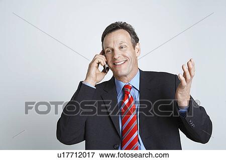 Studio shot of businessman talking on mobile phone View Large Photo Image Stock Photo - Studio shot of businessman talking on mobile phone. Fotosearch