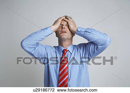 Studio shot of businessman with head in hands View Large Photo Image Stock Image - Studio shot of businessman with head in hands. Fotosearch