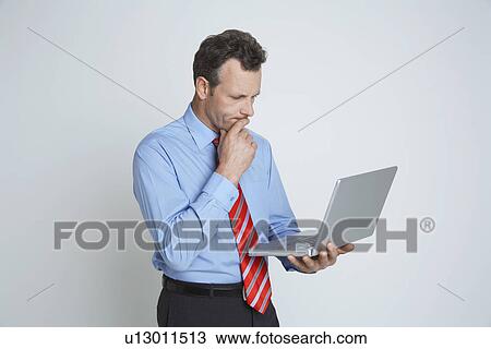 Studio shot of businessman with laptop View Large Photo Image Stock Image - Studio shot of businessman with laptop. Fotosearch