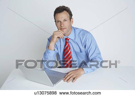 Studio shot of businessman with laptop View Large Photo Image Stock Photo - Studio shot of businessman with laptop. Fotosearch