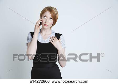 Stock Photograph - Studio shot of businesswoman talking on mobile phone. Fotosearch
