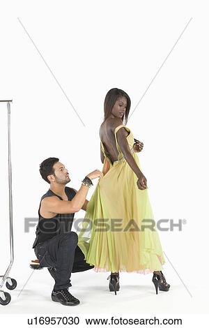 Stylist adjusts dress in fitting View Large Photo Image Stock Image - Stylist adjusts dress in fitting. Fotosearch