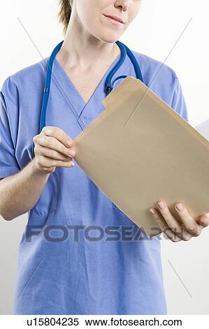 Stock Photography - Surgeon with medical file, mid section. Fotosearch